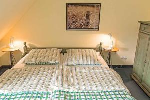 ein Bett mit zwei Kissen darauf in einem Schlafzimmer in der Unterkunft Ferienhaussiedlung Strandperlen Küstenhof 2c Typ V in Wustrow