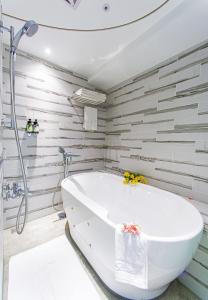 a white bath tub in a bathroom with wooden walls at Norway Forest Travel hotel 1 Taichung in Taichung