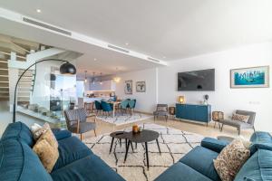 a living room with a blue couch and a table at VACATION MARBELLA I Casa Isabel, Private Pool, Luxury Condo, Top Location in Marbella