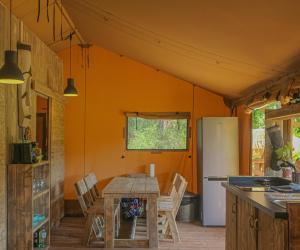 eine Küche mit einem Holztisch und einem Kühlschrank in der Unterkunft Lodge St Exupéry in Le Thor
