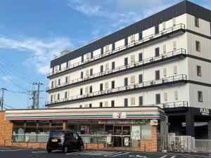 a car parked in front of a large building at PLAZA IN KANKU Hotel in Sano