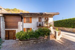 a house with a wooden door and a balcony at Borgo Cantagallo Casa Olivia 2 in Tremosine Sul Garda