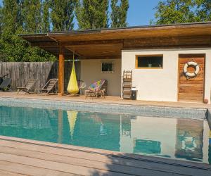 a house with a swimming pool in front of it at Lodge St Exupéry in Le Thor
