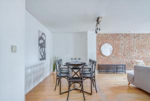 een eetkamer met een tafel en stoelen en een bakstenen muur bij NOCNOC - L'Alto, Monnaie in Lille