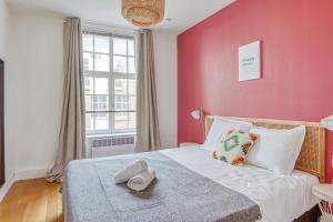 een slaapkamer met een bed met een roze muur bij NOCNOC - L'Alto, Monnaie in Lille