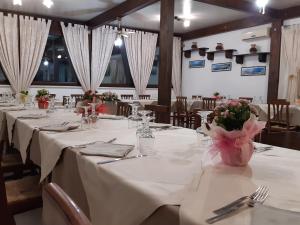 une salle à manger avec des tables et des nappes blanches dans l'établissement Agriturismo Terra dei Profumi, à Otrante