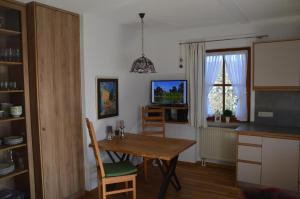 une cuisine avec une table en bois et une salle à manger dans l'établissement Ferienwohnung Chiemseestrand Nr. 16, à Arlaching