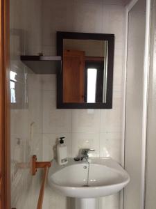 a bathroom with a sink and a mirror at Bungalow 1 - Playa Arnela in Carballo +28 photos