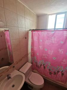 baño con cortina de ducha rosa y aseo en Escapaditas a la Playa, en Tonsupa