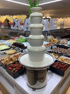 a dessert buffet with a tall white tower on a counter at Hotel Xaine Park in Lloret de Mar