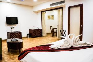 a hotel room with a bed and a tv at Hotel Adityaz in Gwalior