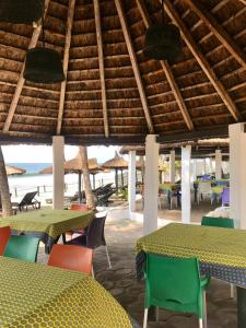 ein Restaurant mit Tischen und Stühlen und der Strand in der Unterkunft Boblin la Mer hotel restaurant plage in Grand-Bassam