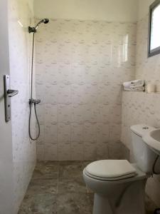 a bathroom with a shower and a toilet and a sink at Boblin la Mer hotel restaurant plage in Grand-Bassam