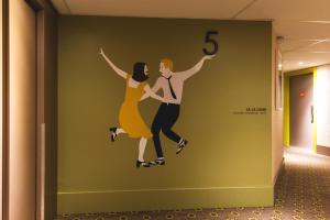 a mural of two people dancing on a wall at ibis Styles Lyon Centre Confluence in Lyon