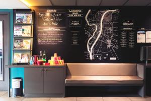 un restaurant avec un menu sur un mur avec un banc dans l'établissement ibis Styles Lyon Centre Confluence, à Lyon