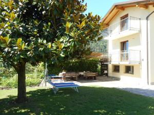 un banco azul en un patio junto a una casa en Appartamenti Casa Viviana, en Pergine Valsugana