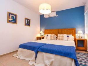 - une chambre avec un grand lit et un mur bleu dans l'établissement VILLA JARAMA Elegante chalet cerca de la playa, à Binibeca