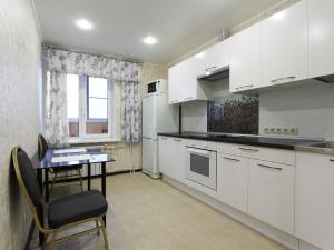 a kitchen with white cabinets and a table and a window at ApartLux Aviamotornaya in Moscow