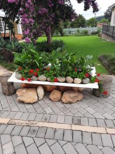 a bench with flowers and plants on a patio at Villa Beryl Guesthouse in Vryheid