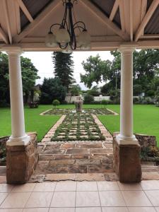 an outdoor pavilion with a stone walkway and columns at Villa Beryl Guesthouse in Vryheid