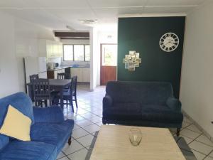 a living room with two blue chairs and a table at The Dunes in St Lucia