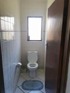 a small bathroom with a toilet and a window at The Dunes in St Lucia