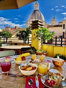 uma mesa com tigelas de comida numa varanda em Navona Residenza de Charme em Roma