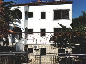 a white building with a fence in front of it at Apartments Vila Tisa in Mali Lošinj