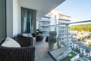 balkon z 2 krzesłami i szklanym stołem w obiekcie Balticus Apartamenty Promenada Gwiazd 14 w mieście Międzyzdroje