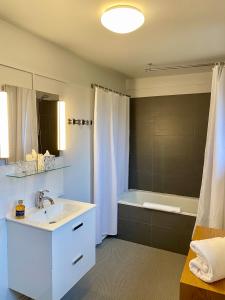 a bathroom with a white sink and a bath tub at Fab House - Les Maisons Fabuleuses in Senlis