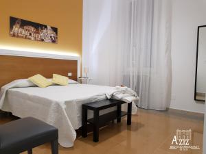 a bedroom with a large white bed with a table at Aziz b&b in Palermo