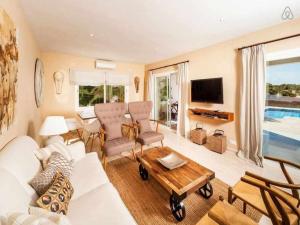 sala de estar con sofá blanco y mesa en Villa Bini Xoroi Fabulosa propiedad para grupos, en Binibeca