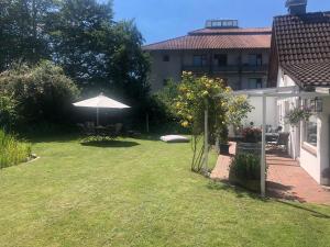 a garden with an umbrella and a table and chairs at Aparthotel Stibbe in Horn-Bad Meinberg