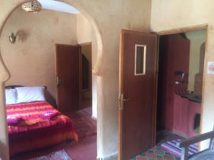 a bedroom with a bed and an open door at Auberge Le Festival Todra Gorge in Aït Baha