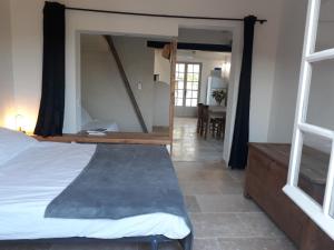 una camera da letto con un letto con un grande specchio di La Petite Maison Dans Les Vignes a Chamaret