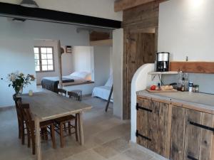 cocina y sala de estar con mesa y sillas en La Petite Maison Dans Les Vignes, en Chamaret