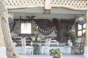 Itziar的住宿－阿里奧拉塔希奇鄉村民宿，凉亭配有白色的椅子、桌子和窗户
