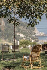 two benches sitting in the grass under a tree at Arriola Txiki in Itziar