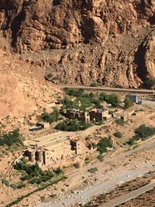 un villaggio nel mezzo di un deserto con una montagna di Auberge Le Festival Todra Gorge ad Aït Baha