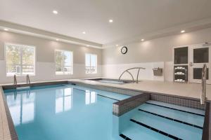 a large swimming pool with blue water in a house at Microtel Inn & Suites by Wyndham Kelowna in Kelowna