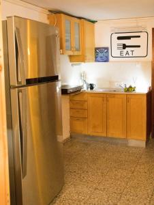 
a kitchen with a refrigerator, stove, sink and cabinets at Exodus Hostel & Dive Center in Eilat
