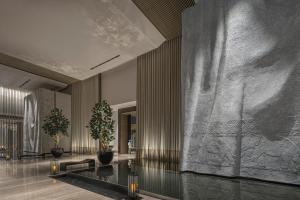 a lobby with a large stone wall with two potted plants at Four Seasons Hotel Bangkok at Chao Phraya River in Bangkok