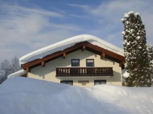 ein schneebedecktes Haus mit Balkon in der Unterkunft Haus Zimmermann - Chiemgau Karte in Inzell