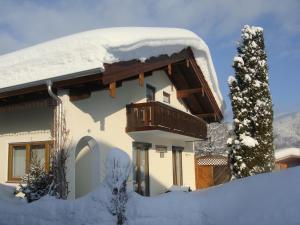 ein schneebedecktes Haus mit Balkon in der Unterkunft Haus Zimmermann - Chiemgau Karte in Inzell