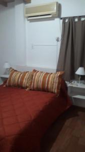 ein Schlafzimmer mit einem Bett mit einem Kissen und einer Heizung in der Unterkunft APART Hotel APH in Reconquista