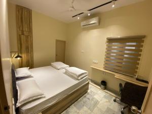 a bedroom with a white bed and a window at Backpackers Den in Lucknow