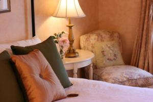 a bedroom with a bed with a chair and a lamp at Captain Farris House in South Yarmouth