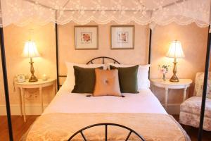 a bedroom with a bed with two tables and two lamps at Captain Farris House in South Yarmouth