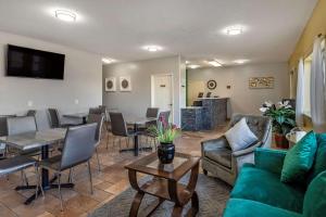 uma sala de estar com um sofá, uma mesa e cadeiras em Quality Inn Kirksville em Kirksville