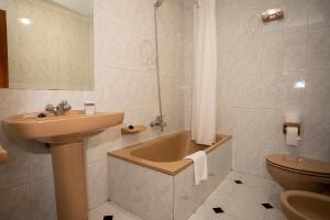 y baño con lavabo, bañera y aseo. en TuristiQA - Piso Carballo Ferrol VUTCO01445, en Ferrol